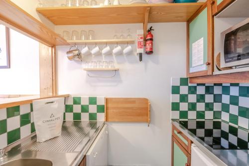 夏慕尼白朗峰的住宿－Chamois Blanc，厨房的墙壁上铺有绿色和白色的格子瓷砖。