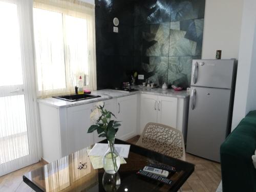 a kitchen with a white refrigerator and a table at Residence Debbabi sans coupure d'eau in Monastir