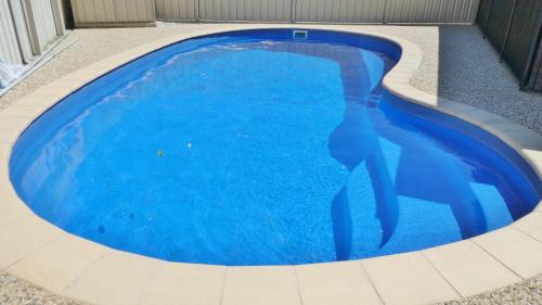 a large blue swimming pool in a house at 25 Admiralty Court, Yamba in Yamba