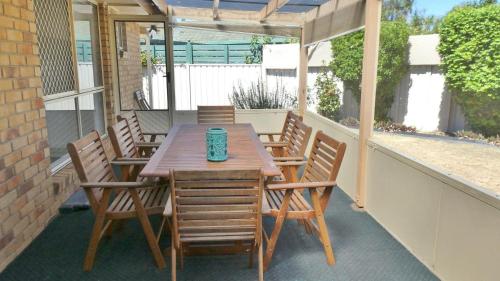 a wooden table and chairs on a patio at 25 Admiralty Court, Yamba in Yamba