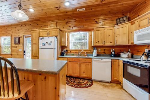 a kitchen with wooden cabinets and a white refrigerator at Toccoa River Retreat in Suches