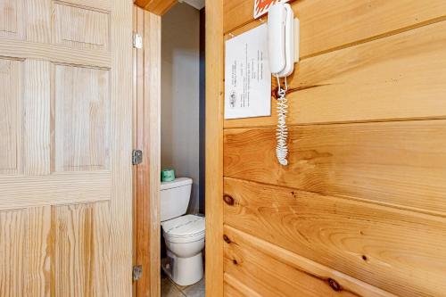 a bathroom with a toilet and a phone on a wooden door at Toccoa River Retreat in Suches