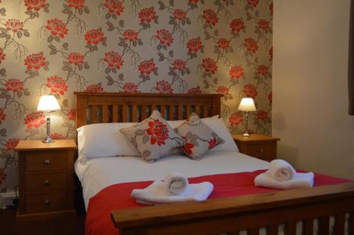a bedroom with a bed with towels on it at The Crown Inn Hotel in Long Melford