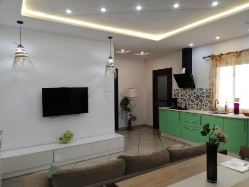 a living room with a couch and a tv on a wall at Residence Debbabi sans coupure d'eau in Monastir