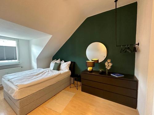a bedroom with a bed and a mirror on a dresser at Traumwohnung - Charmante Citywohnung nahe Hauptbahnhof in Koblenz