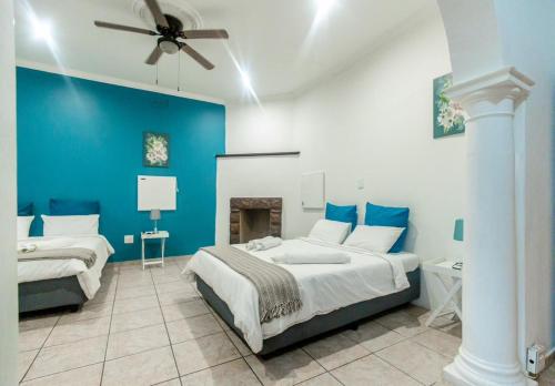 a blue and white bedroom with two beds and a fireplace at 54 Brecher in Pretoria