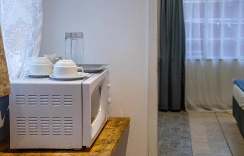 a microwave with dishes on top of it on a table at 54 Brecher in Pretoria