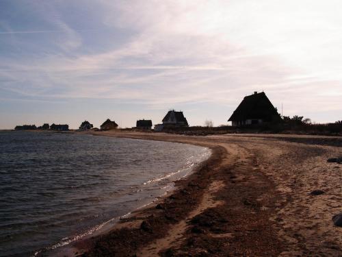 a beach with some huts and the water at exclusives Hausboot "Tante Trost" in Heiligenhafen