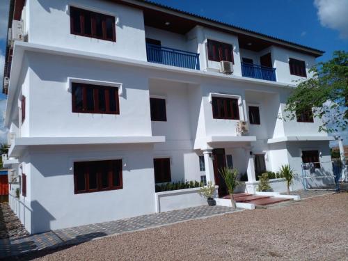 a white building with black shutters on it at Ban Saylomleng Residence in Vientiane