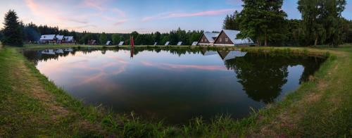 a lake with a house in the middle of it at Jasenka rekreační středisko Zubří in Nové Město na Moravě