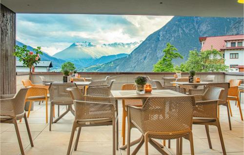 a restaurant with tables and chairs and a view of mountains at Wally Berg Ferienwohnung in Zams