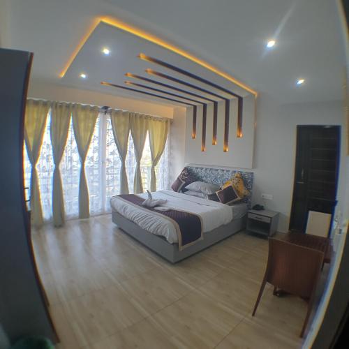 a bedroom with a large bed and some windows at Zingo's Home Stay in Darjeeling