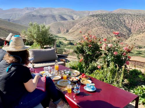a group of people sitting at a table eating food at Touda Ecolodge Atlas Mountains in Zawyat Oulmzi