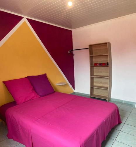 - une chambre avec un lit rose et une étagère dans l'établissement Le petit cactus 2, à Bras-Panon
