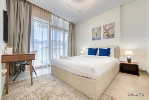 een slaapkamer met een bed, een bureau en een raam bij Expansive 2BR at Azizi Aliyah Dubai Healthcare City by Deluxe Holiday Homes in Dubai