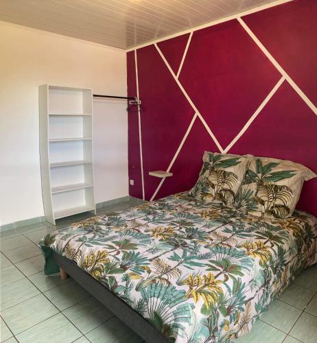 a bedroom with a bed with a purple wall at Le petit cactus 2 in Bras-Panon