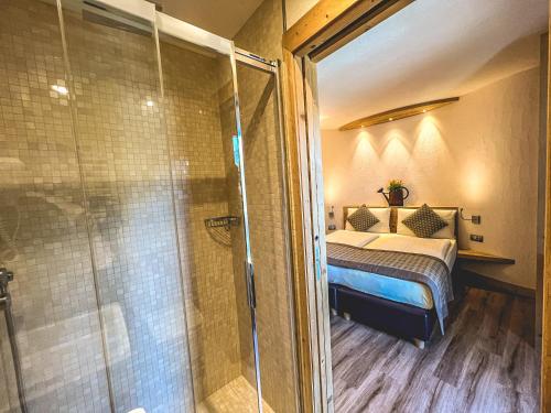 een slaapkamer met een bed en een glazen douche bij Casa Meta in Livigno