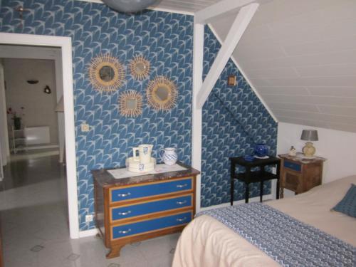 um quarto com uma cama e uma parede azul em Mittenbach em Oberhaslach