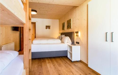 2 Betten in einem kleinen Zimmer mit Holzwänden in der Unterkunft Moderne Ferienwohnung In Zams in Zams