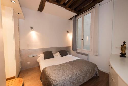 - une chambre avec un lit et une grande fenêtre dans l'établissement Couleur St Martin, à Paris