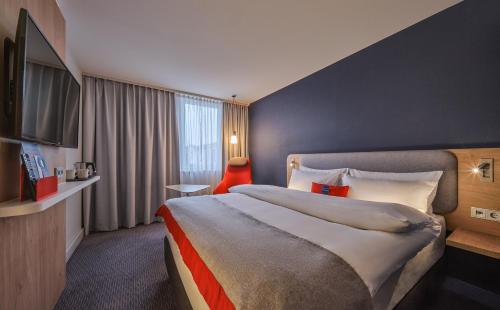 ein Hotelzimmer mit einem großen Bett und einem Fenster in der Unterkunft Holiday Inn Express Berlin City Centre, an IHG Hotel in Berlin