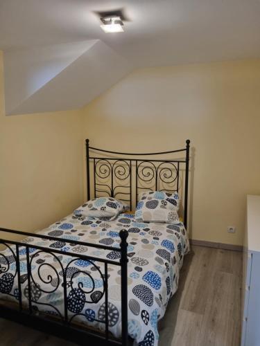 1 dormitorio con 1 cama con edredón azul y blanco en T1 meublé, en Saint-Chamond