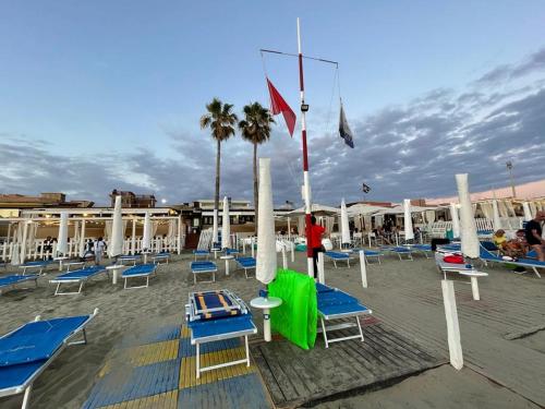 a group of chairs and flags on a beach at Le Sirene Casa Vacanza in Torvaianica