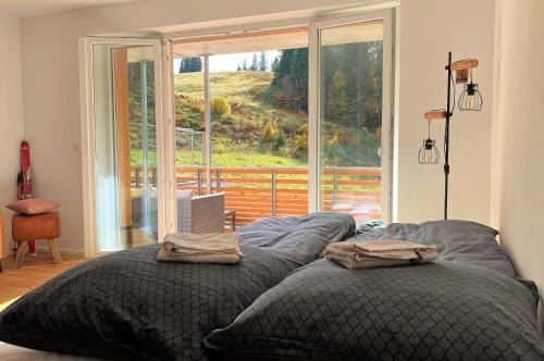 a bedroom with two beds and a large window at Wiesenquell Apartment Feldberg in Feldberg