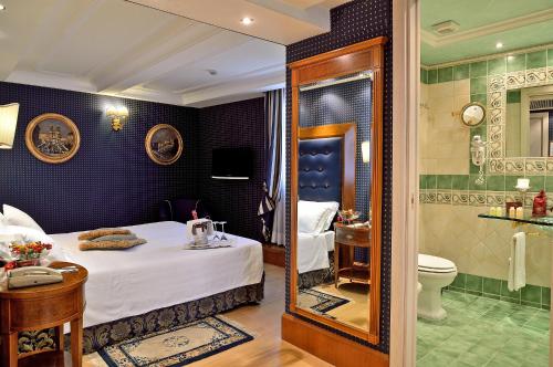 a hotel room with a bed and a bathroom at Hotel Homs in Rome