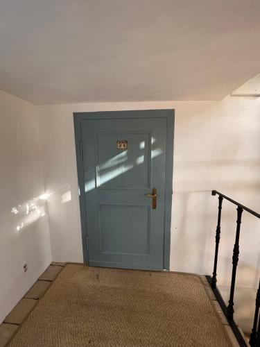a blue door with a sign on it in a room at Dom po schodkach in Wleń
