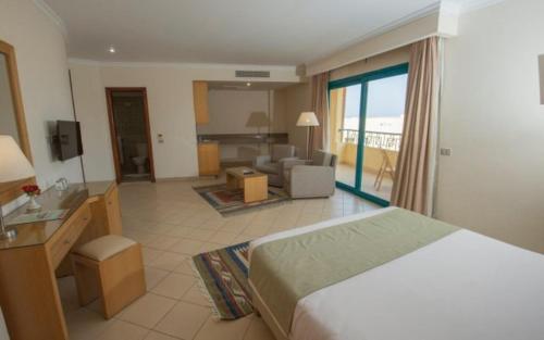 een hotelkamer met een bed en een woonkamer bij Eagles down town Zahabia &Beach Resort in Hurghada