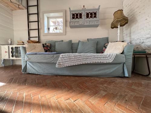 a blue couch in a living room with a wooden floor at Dom po schodkach in Wleń