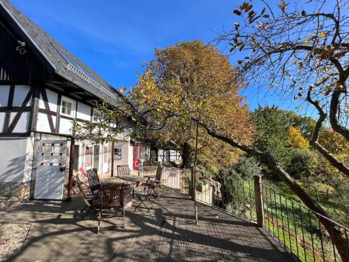 a deck with chairs and a table in front of a house at Dom po schodkach in Wleń