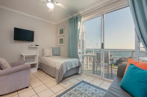 ein Schlafzimmer mit Bett und Blick auf das Meer in der Unterkunft Albatross Accommodation in Lambertʼs Bay