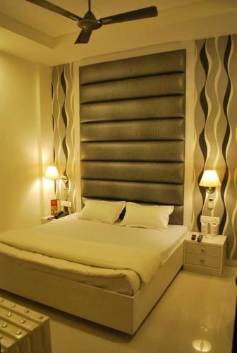 a bedroom with a large bed with a ceiling fan at Hotel Arina Inn in New Delhi