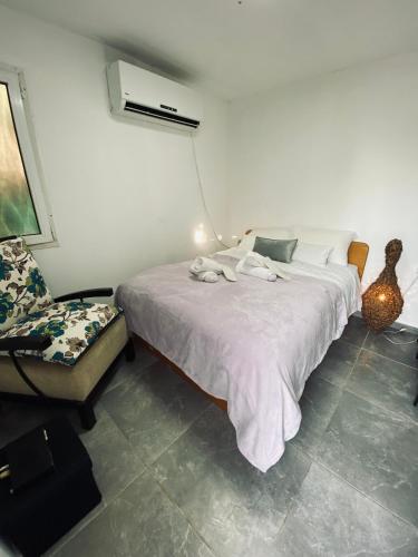 a bedroom with a white bed and a chair at Yogo Place in Nahariyya in Nahariyya