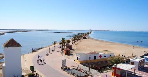 a beach with a group of people walking on the beach at Hotel Arce in San Pedro del Pinatar
