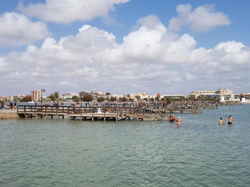 a group of people in the water near a pier at Hotel Arce in San Pedro del Pinatar