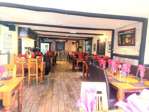 a restaurant with wooden tables and chairs with pink napkins at The Black Lion Royal Hotel in Lampeter