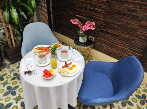 a table with breakfast food and a blue chair at Hotel Boutique Quinta Camacho in Bogotá