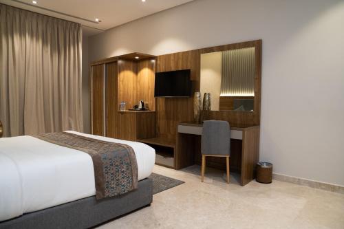 ジッダにあるSarwat Park Hotel Jeddahのベッドとデスクが備わるホテルルームです。
