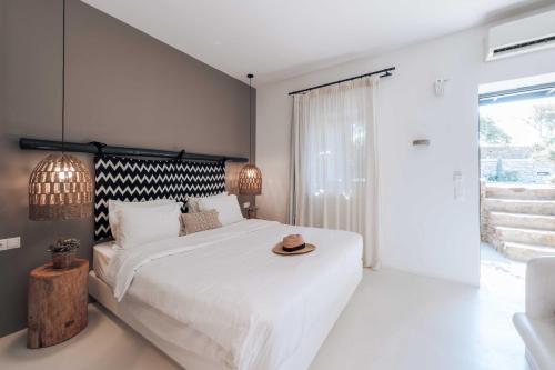 a bedroom with a bed with a hat on it at My Mykonos Hotel in Mýkonos City