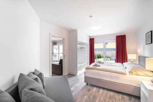 une chambre avec un grand lit et un canapé dans l'établissement Apartment Ski&Nature "Grosseck", à Mauterndorf