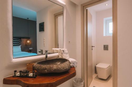 a bathroom with a sink and a mirror at My Mykonos Hotel in Mýkonos City