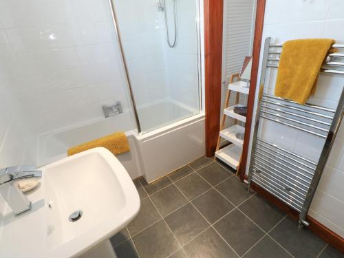 W łazience znajduje się biała umywalka i prysznic. w obiekcie Glenridding Cottage w mieście Warcop