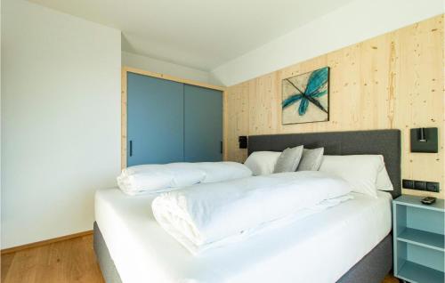 1 dormitorio con cama blanca y pared azul en Beautiful Apartment In Zams With Wifi en Zams