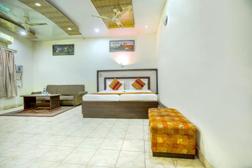 a bedroom with a bed and a couch in a room at Hotel Surya in Ludhiana