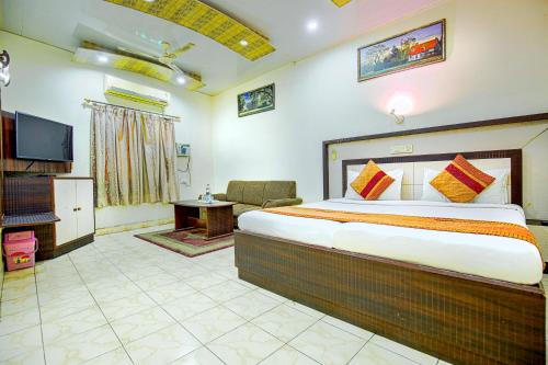 1 dormitorio con 1 cama grande y TV en Hotel Surya en Ludhiana