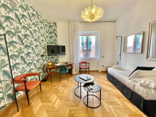 a bedroom with a bed and a desk and a tv at ALMA de Toledo Design Home Plebiscito in Naples