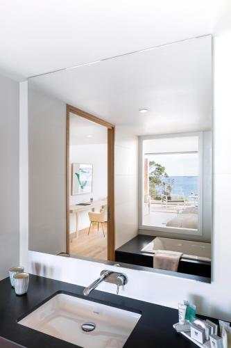 La salle de bains est pourvue d'un grand miroir au-dessus d'un lavabo. dans l'établissement Brittany & Spa Relais & Châteaux, à Roscoff